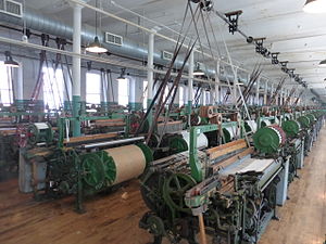 Line_shaft_and_power_looms_at_Boott_Mills,_Lowell,_Massachusetts.JPG